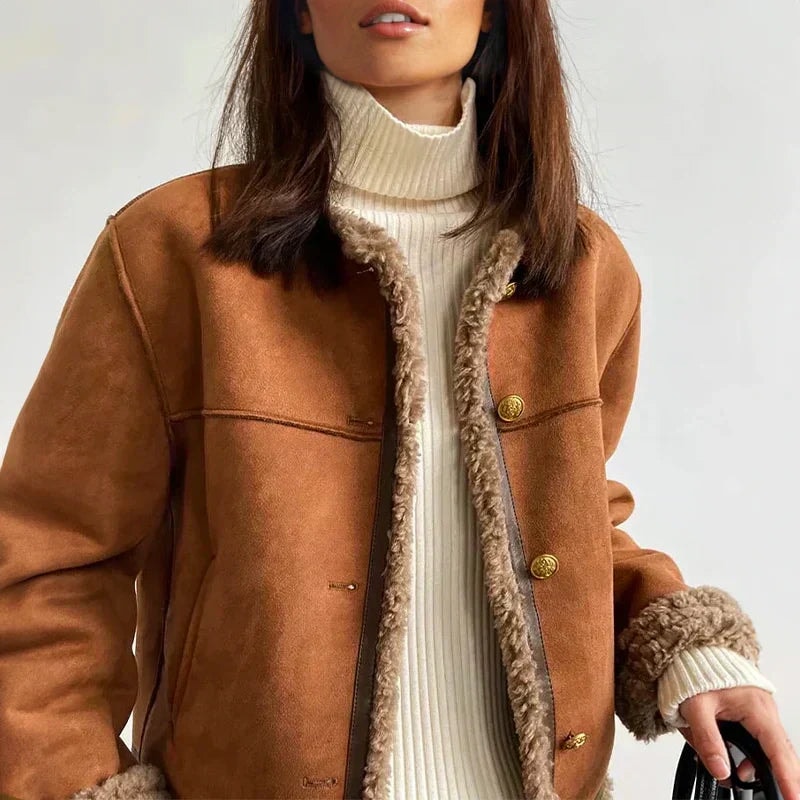 Closer front view highlighting the jacket’s gold-tone button closure, plush front edging and turned-back shearling cuffs.