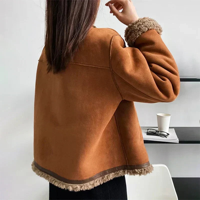 Back view showing the jacket’s smooth brown body, seam detailing, relaxed sleeves and plush trim along the lower hem.