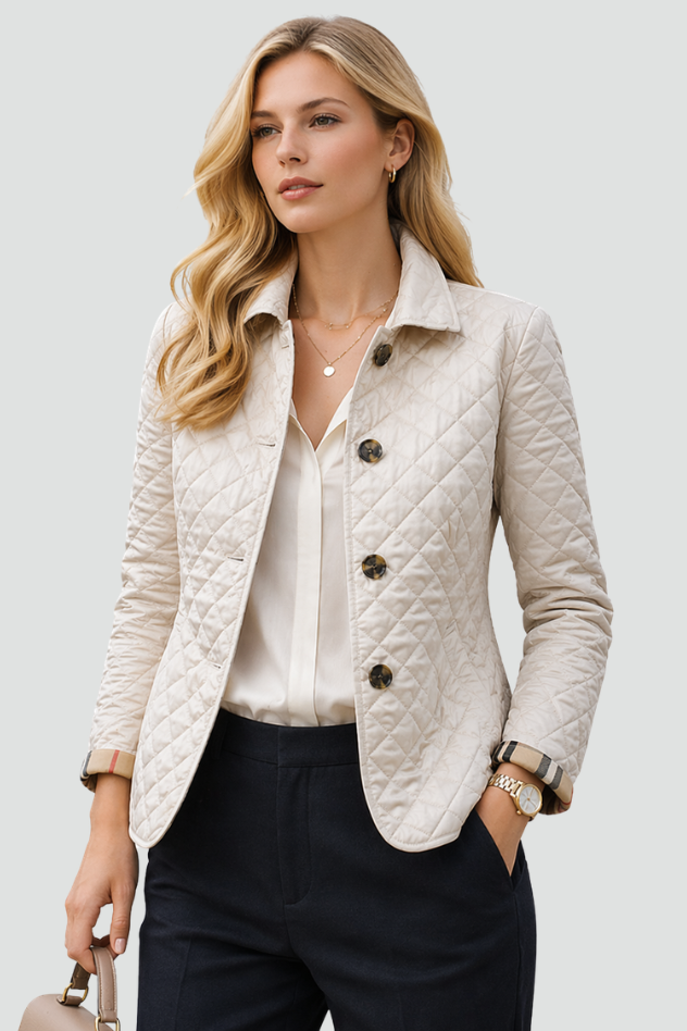 Woman wearing a diamond quilted jacket with point collar, four front buttons and check-lined cuffs over a blouse and tailored trousers._0