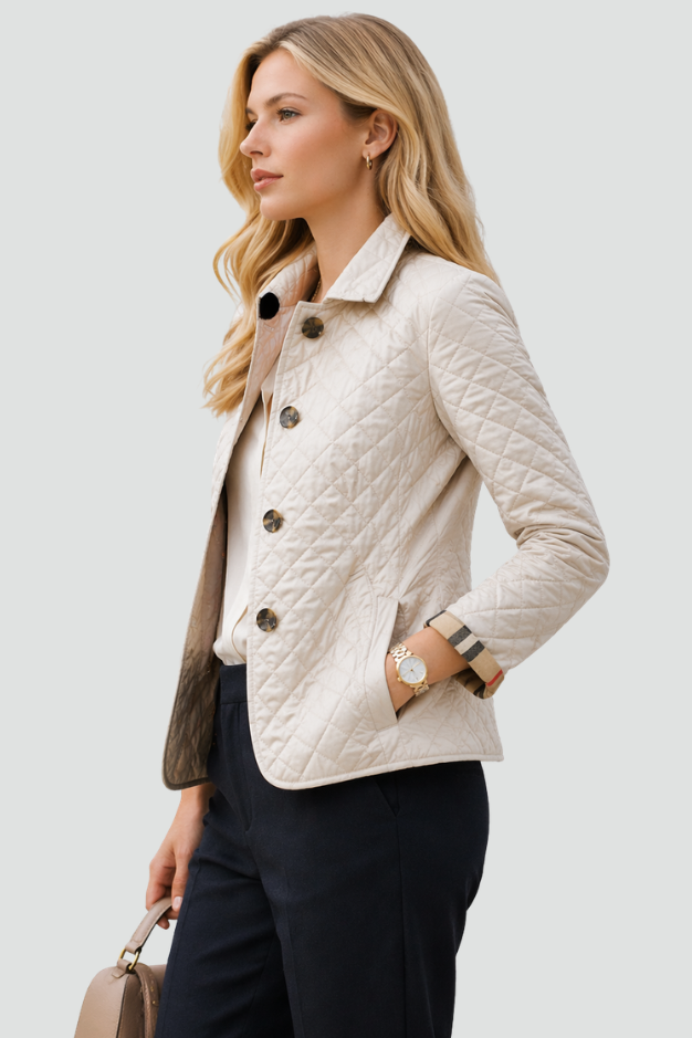 Woman wearing a diamond quilted jacket with point collar, four front buttons and check-lined cuffs over a blouse and tailored trousers._1
