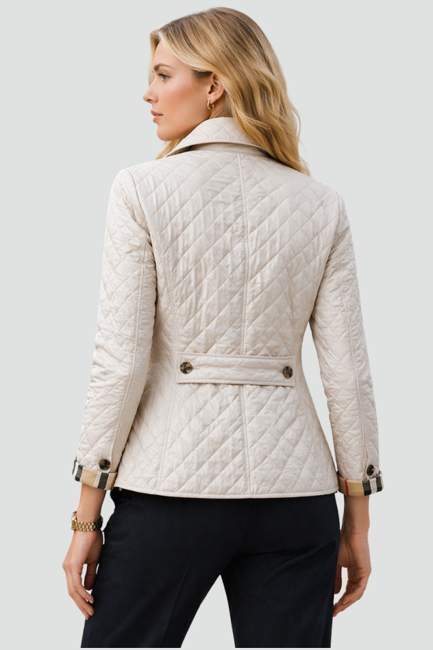 Woman wearing a diamond quilted jacket with point collar, four front buttons and check-lined cuffs over a blouse and tailored trousers._2