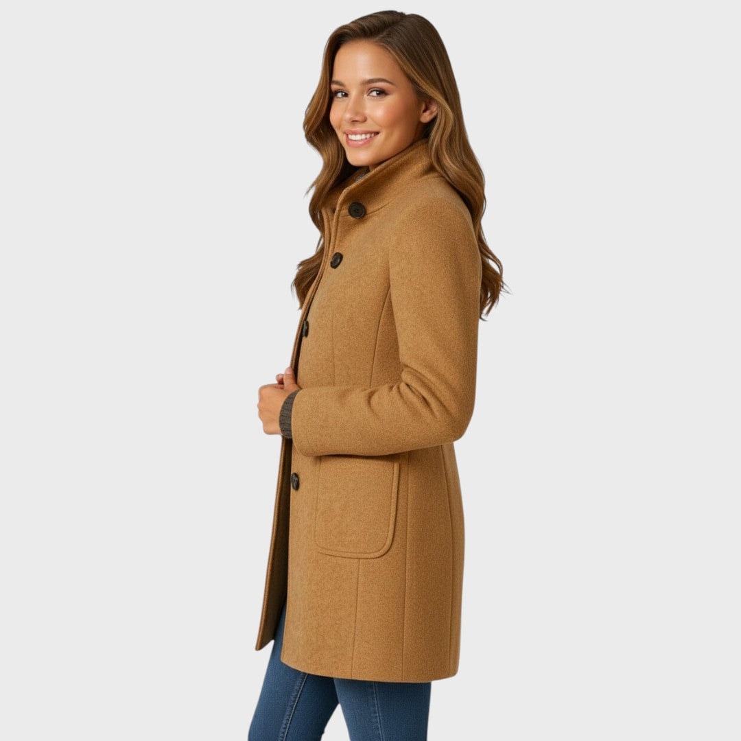 Side view of the camel mid-length coat showing its fitted profile, raised stand collar, sleeve shape, and side placement of a front patch pocket.