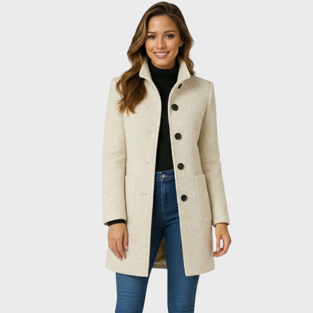 Front view of the ivory mid-length coat worn open at the collar, highlighting the fitted shape, four-button front, and two low patch pockets.
