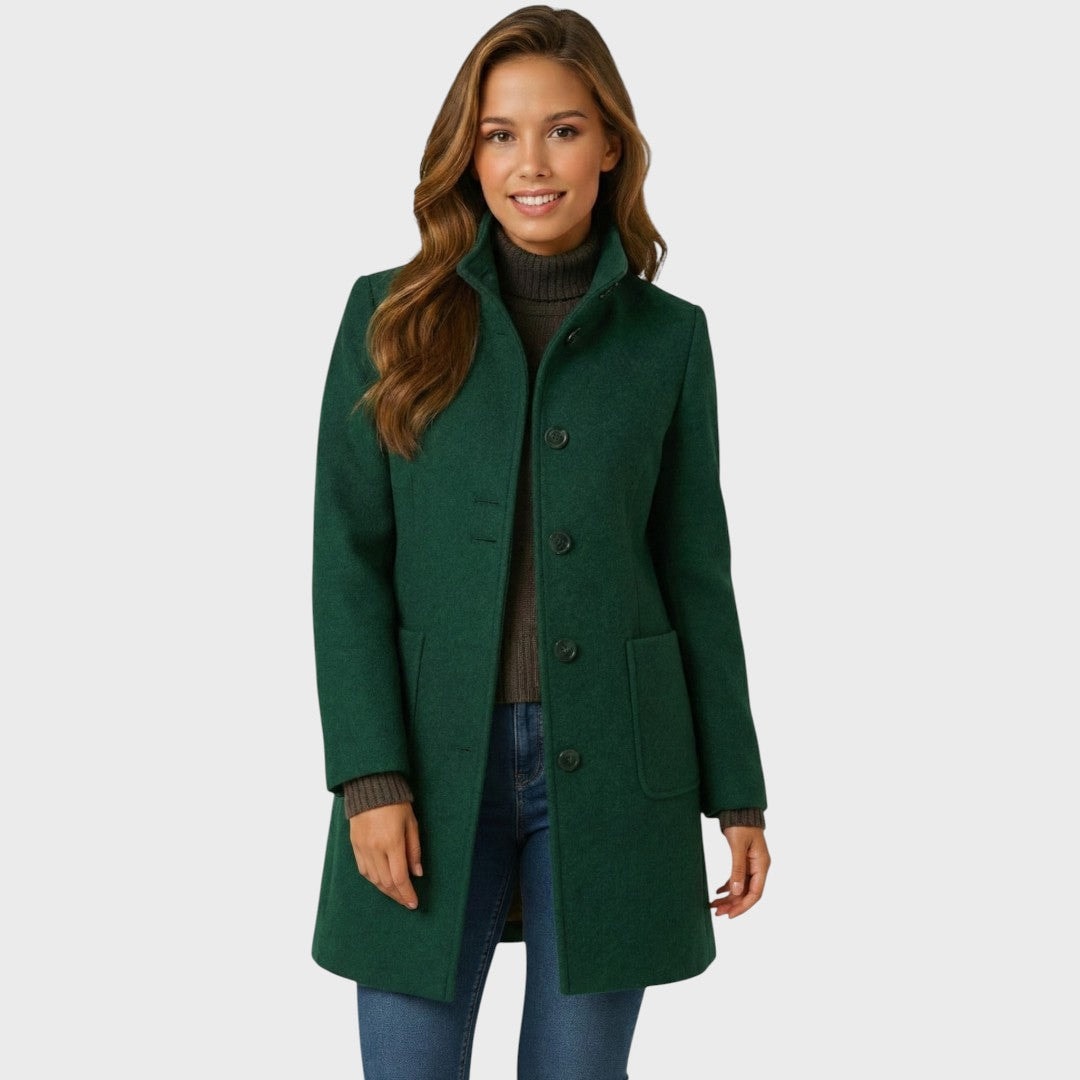 Front view of the dark green mid-length coat showing the structured stand collar, vertical button closure, and two front patch pockets.