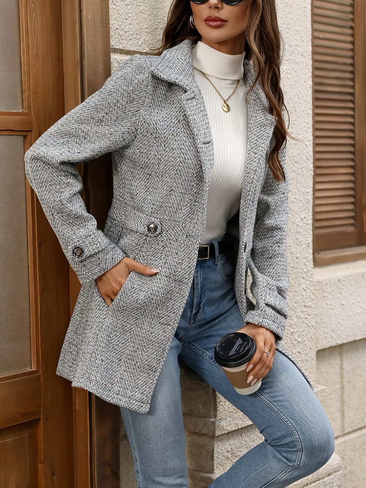 Woman wearing a mid-length herringbone-texture coat with notch lapels, front buttons, waist tabs and side pockets over a roll neck and jeans._3