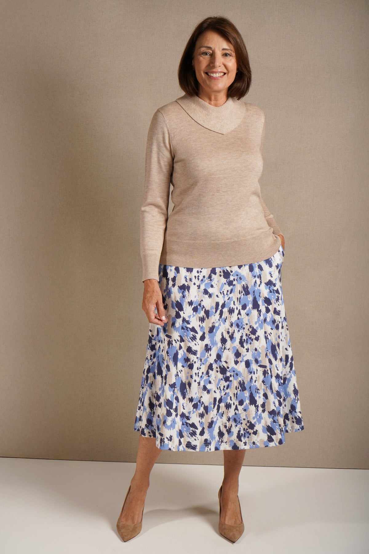 Woman wearing a long sleeve fine knit jumper with a draped cowl neck, ribbed cuffs and hem, with a printed midi skirt._1