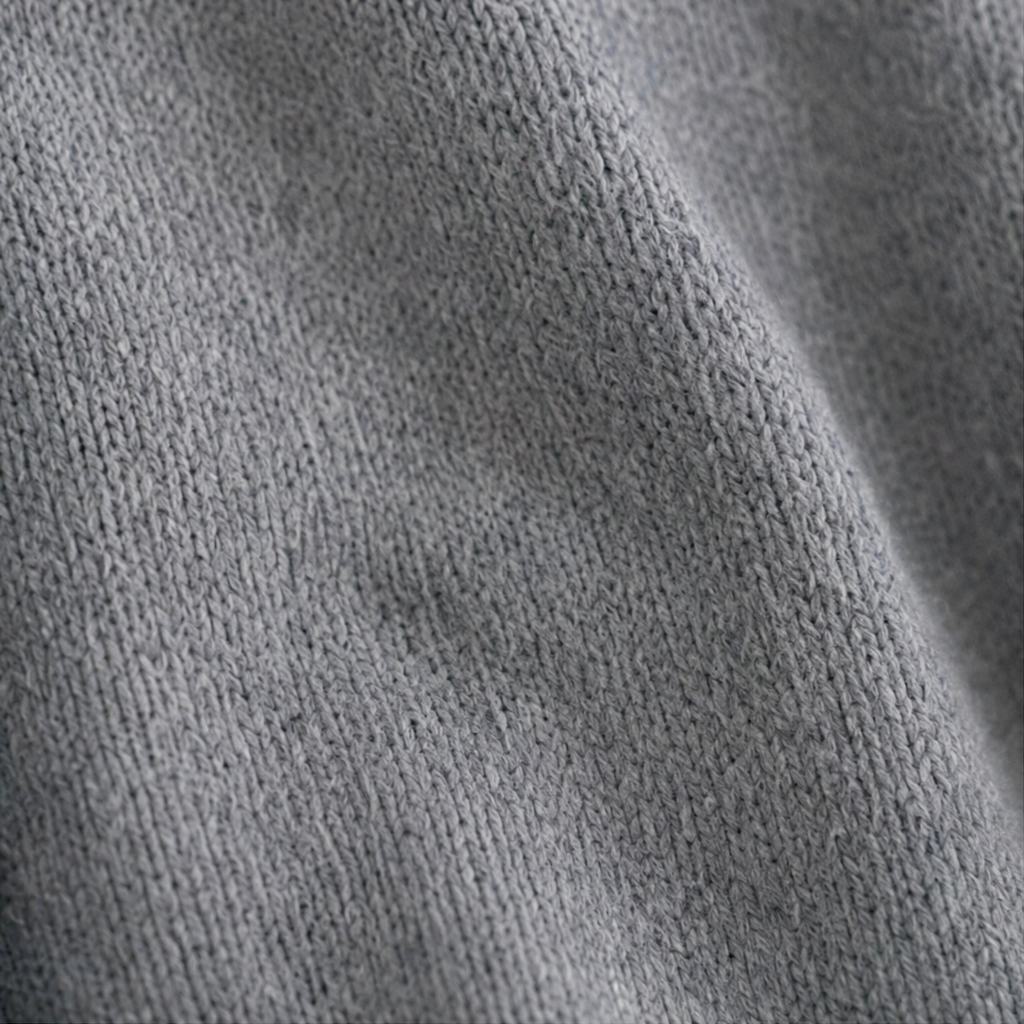 Extreme close-up of the gray cardigan's fine knitted surface.