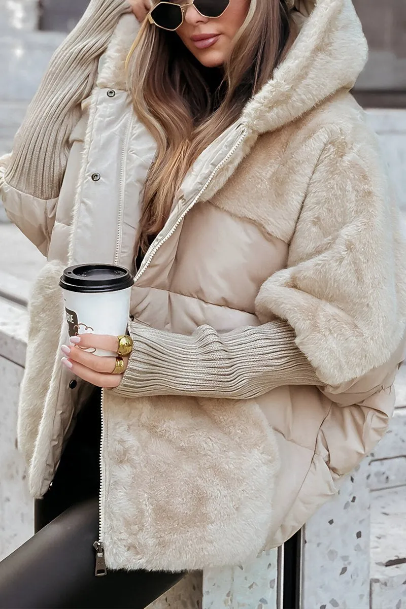 Cream jacket close-up featuring the plush hood, quilted chest section, front zipper, and extended ribbed sleeve.