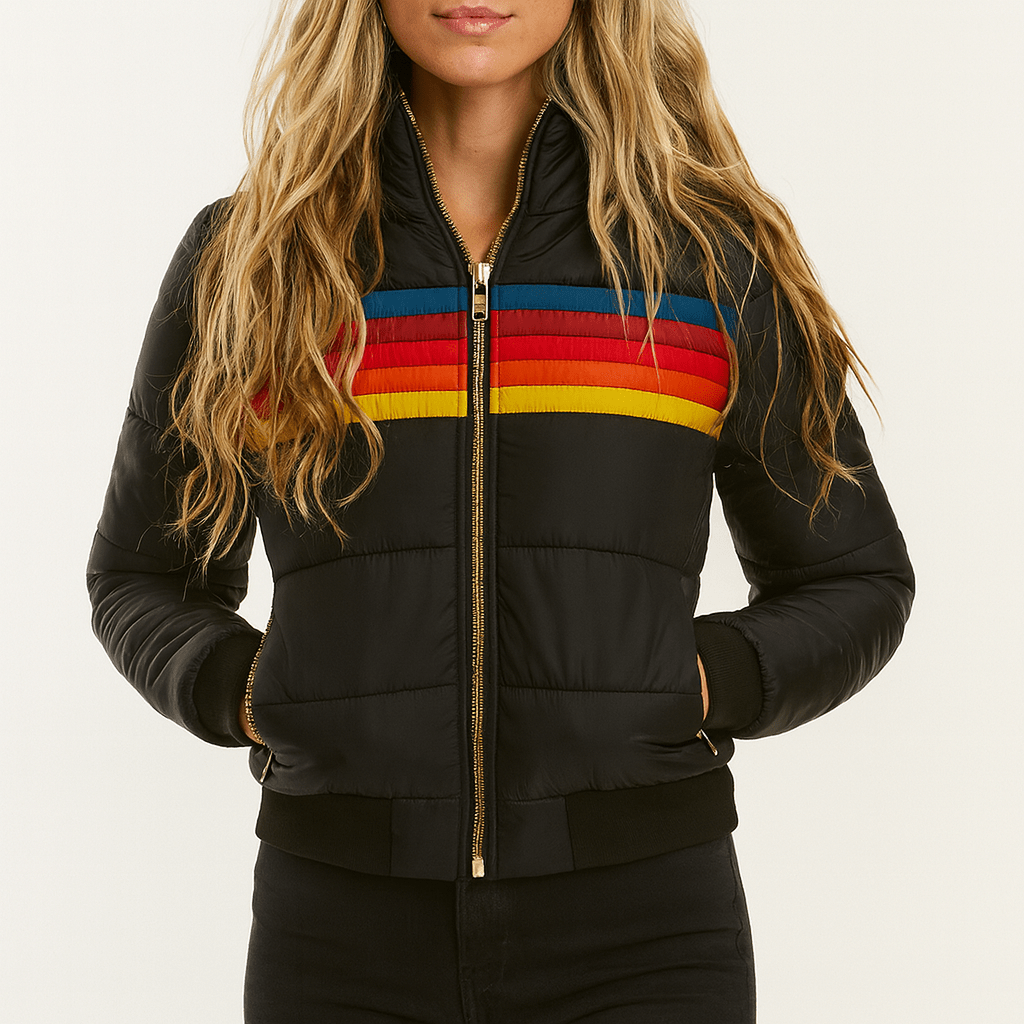 Close front view of the black puffer jacket with bright red, navy, orange, and yellow chest stripes and hands placed in the side pockets.