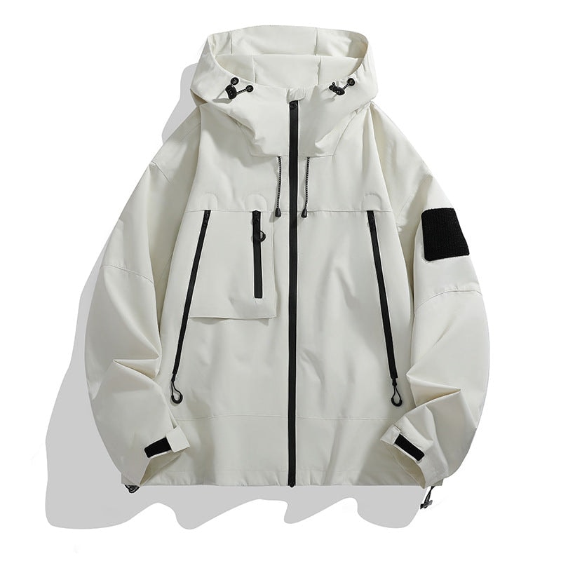 White hooded utility jacket with a full black front zipper, adjustable hood, multiple zip pockets, cuff tabs, and a black sleeve patch.