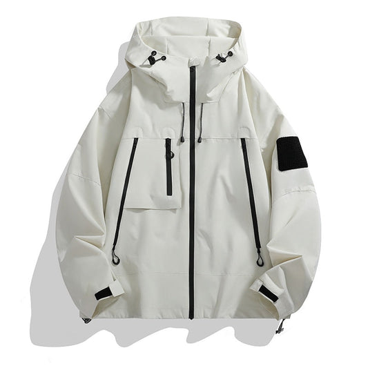 White hooded utility jacket with a full black front zipper, adjustable hood, multiple zip pockets, cuff tabs, and a black sleeve patch.