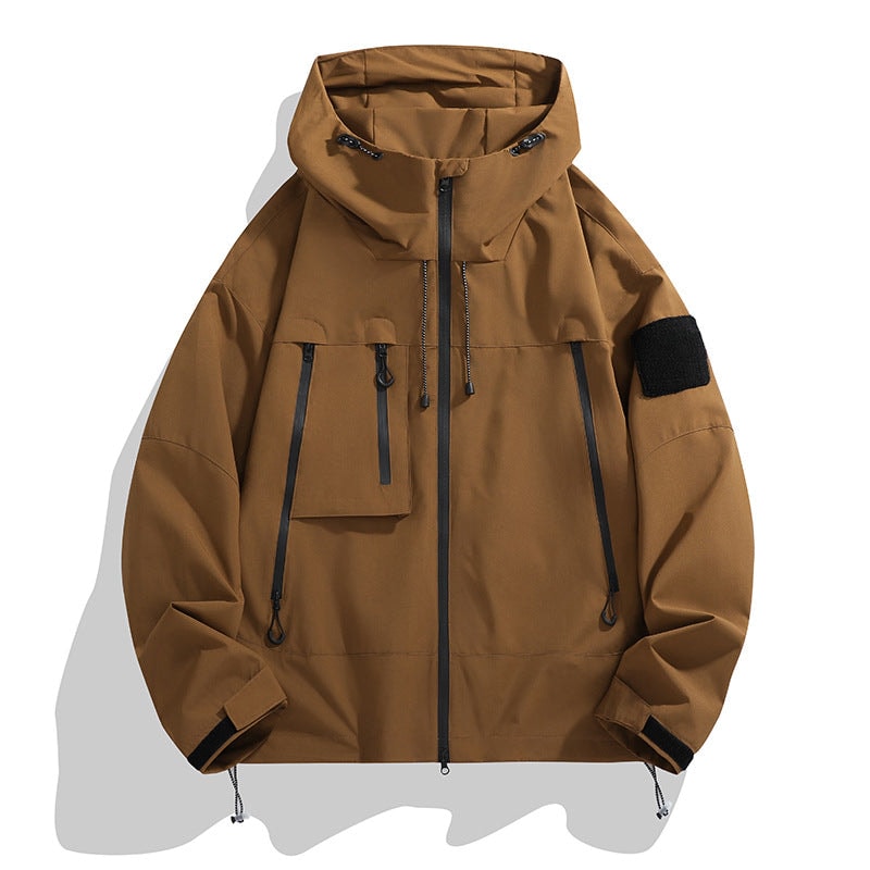 Brown hooded jacket with a full zip closure, multiple black zip pockets, a flap pocket, sleeve patch, and adjustable cuffs.