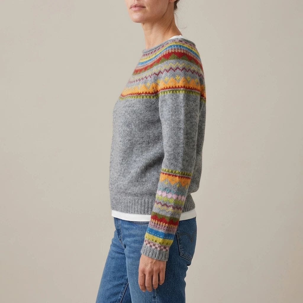 Woman wearing a long sleeve knit jumper with a patterned fair isle yoke and cuffs, boat neckline and ribbed hem, with straight jeans and ankle boots._3