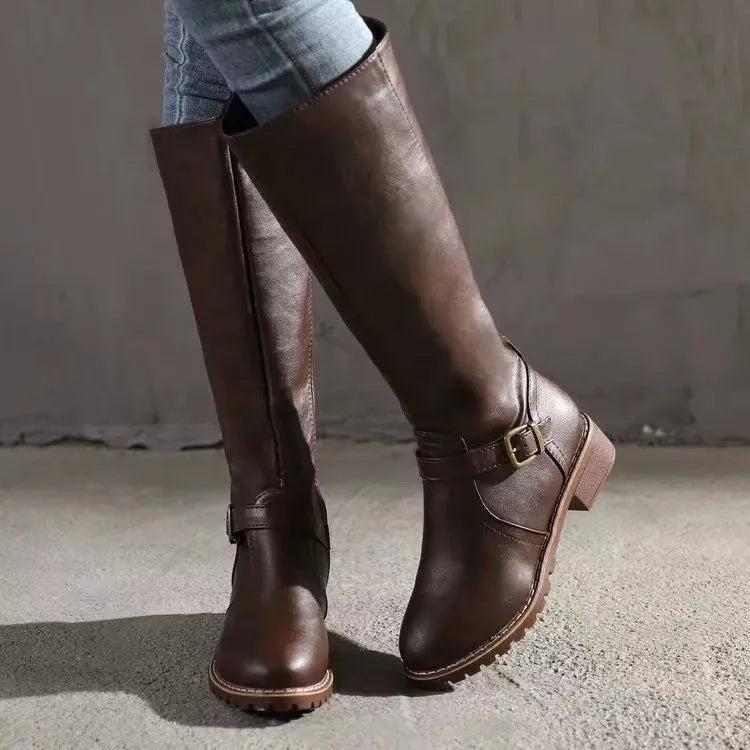 Brown knee-high boots in a side-angled view, highlighting the ankle buckle, low block heel, and textured sole.