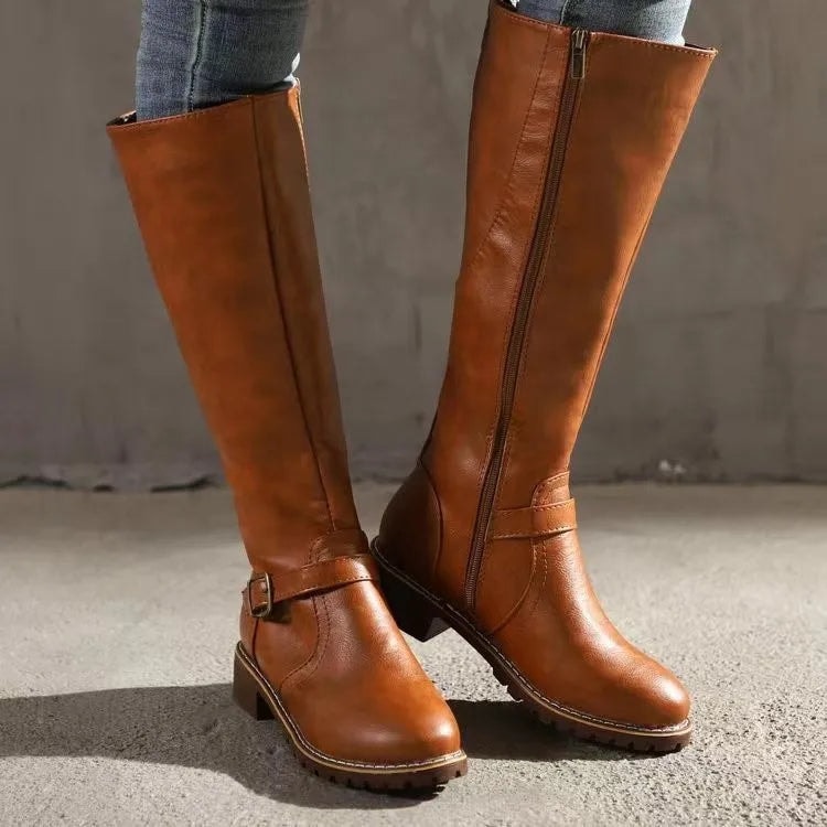 Tan knee-high boots shown from the front and side, featuring ankle buckles, visible side zippers, and sturdy low heels.