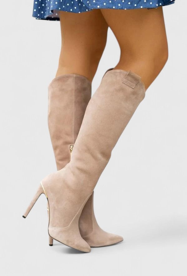 Beige knee-high boots with pointed toes and slim stiletto heels, shown crossed in a side-facing pose.