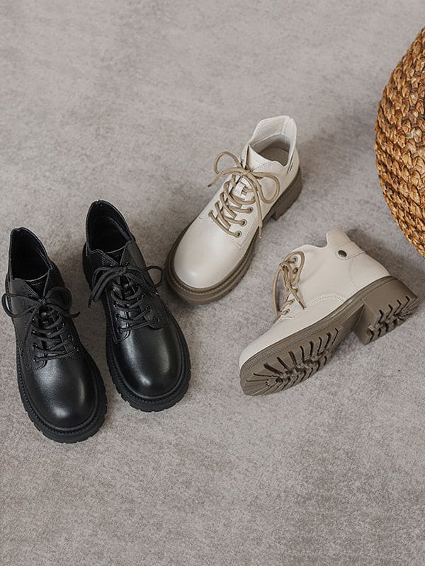 Person lacing up black combat boots with round toe and platform sole while wearing a black skirt._13