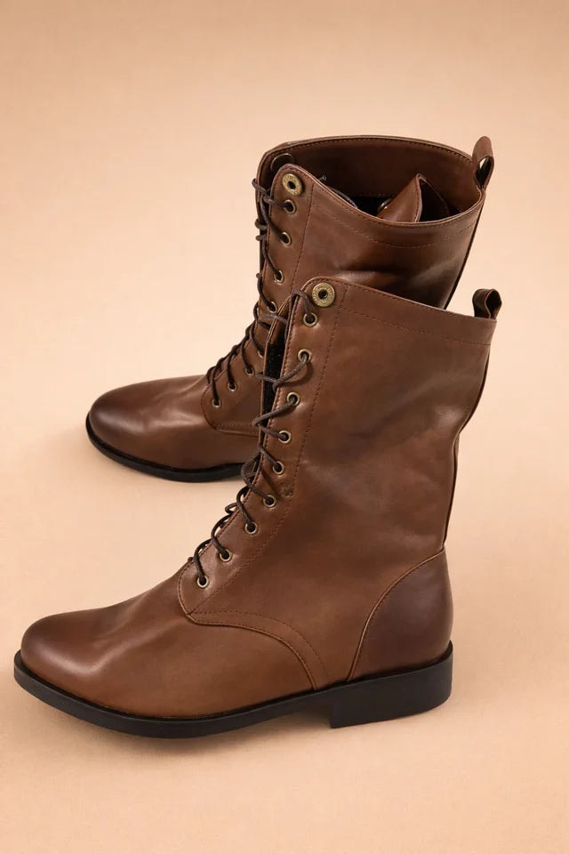 Pair of brown lace-up mid-calf boots shown upright at an angle, with eyelet detailing, rounded toes, and low block heels.