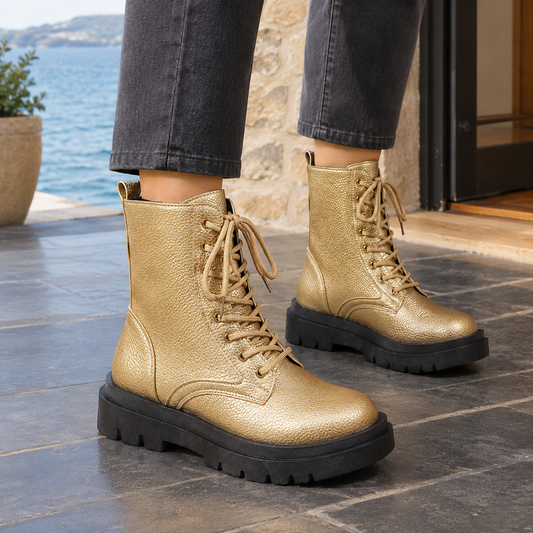 Pair of gold mid-calf lace-up boots with rounded toes, textured uppers, and substantial black platform soles.