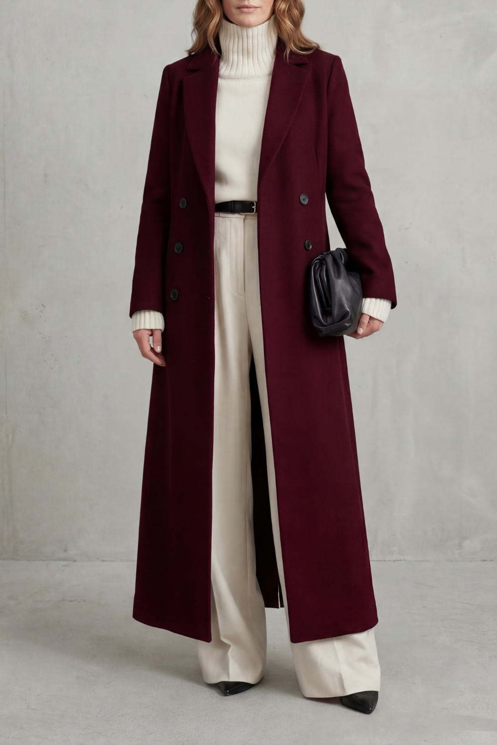 Front view of a deep burgundy long tailored coat with notched lapels, long sleeves and a double-breasted button front.