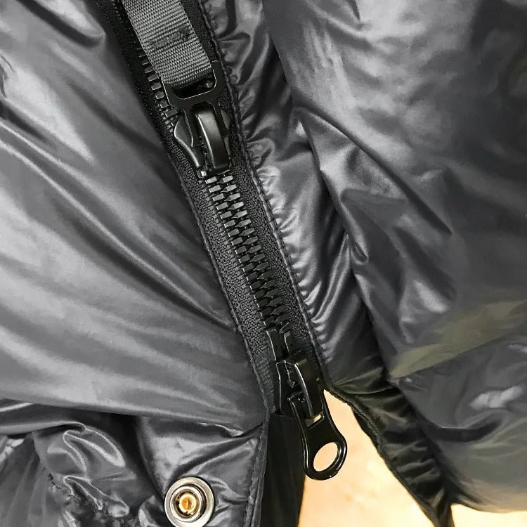 Close-up of the jacket’s two-way zipper hardware and lower snap fastener.