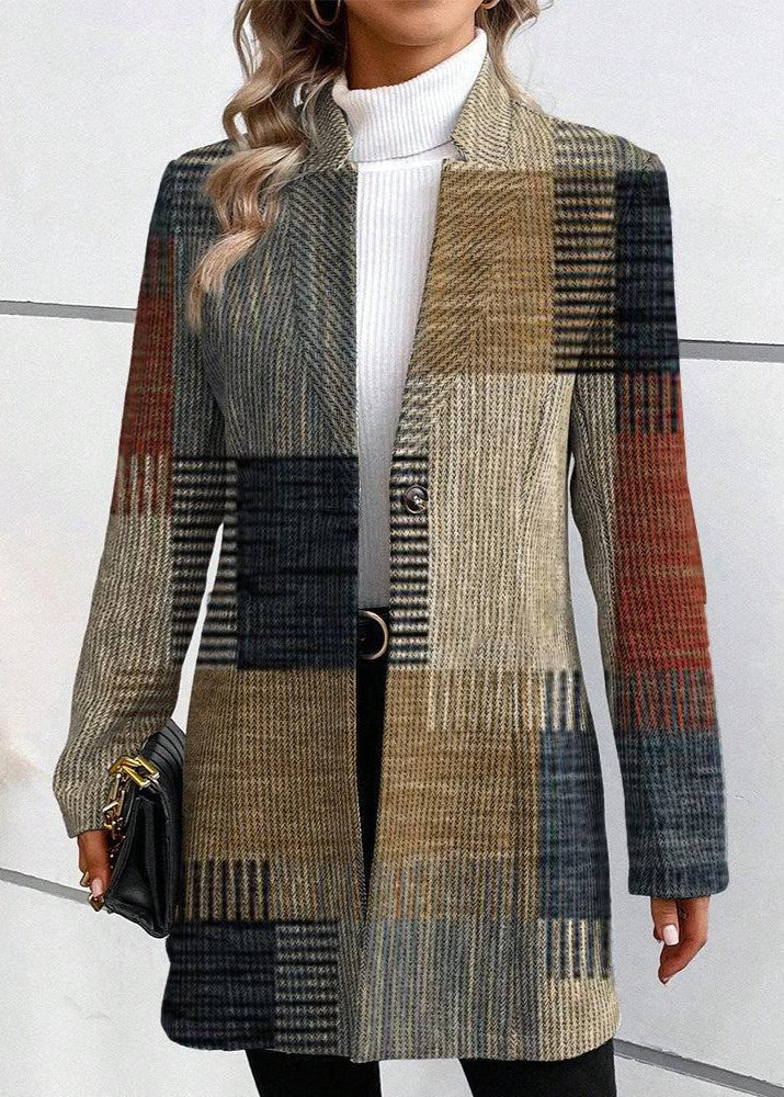 Front view of a long mixed-plaid blazer showing the asymmetrical panel arrangement, notched lapel, and single-button closure over a white turtleneck.