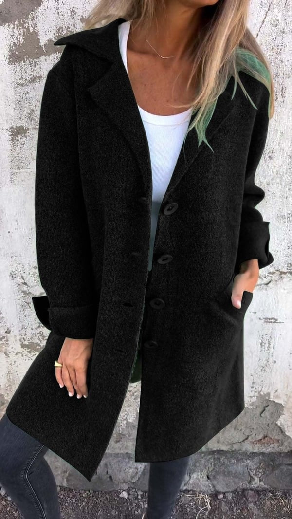 Black longline blazer jacket layered over a white top, featuring prominent notched lapels and a centered button front.