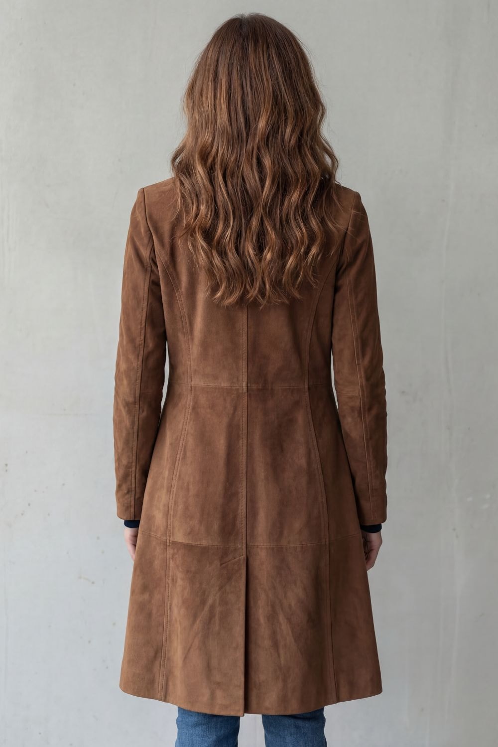 Back view of the brown longline coat highlighting its long length, center back seam, and vintage-style finish.