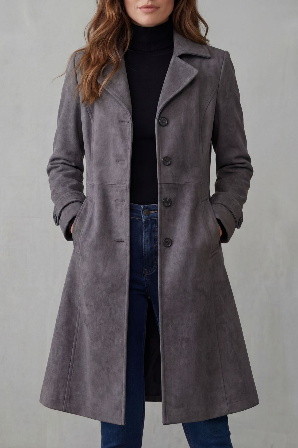 Gray longline coat shown from the front, featuring a classic notched collar, multiple buttons, and hands placed in the side pockets.