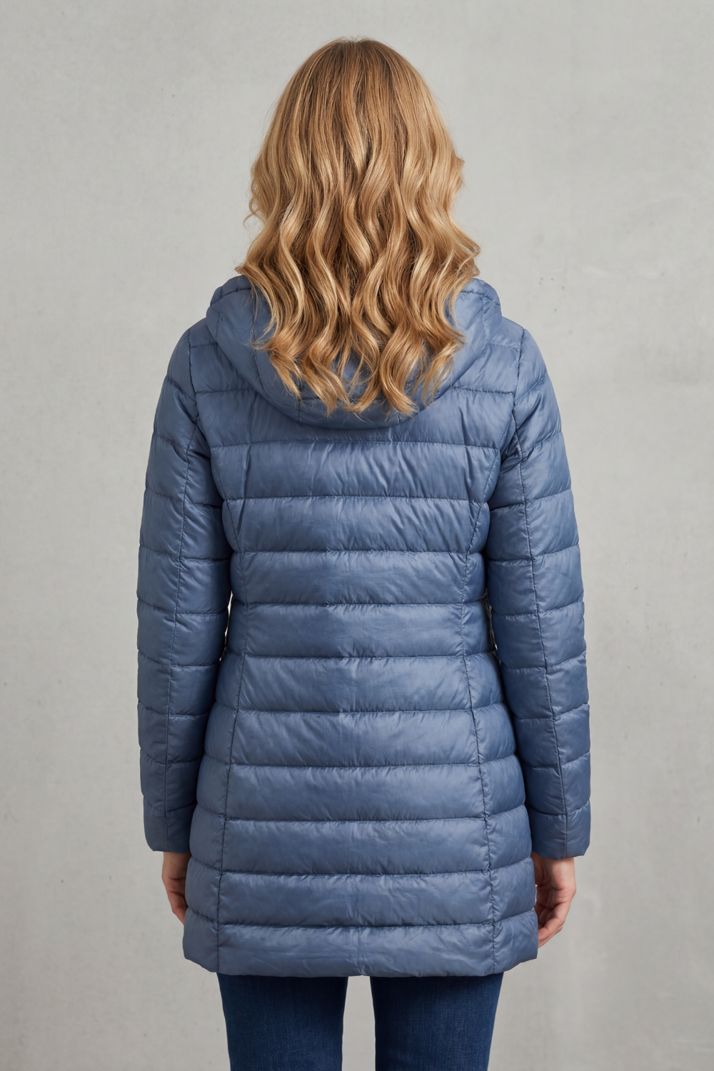 Back view of the blue longline hooded puffer jacket, showing the quilted panels and extended coverage.