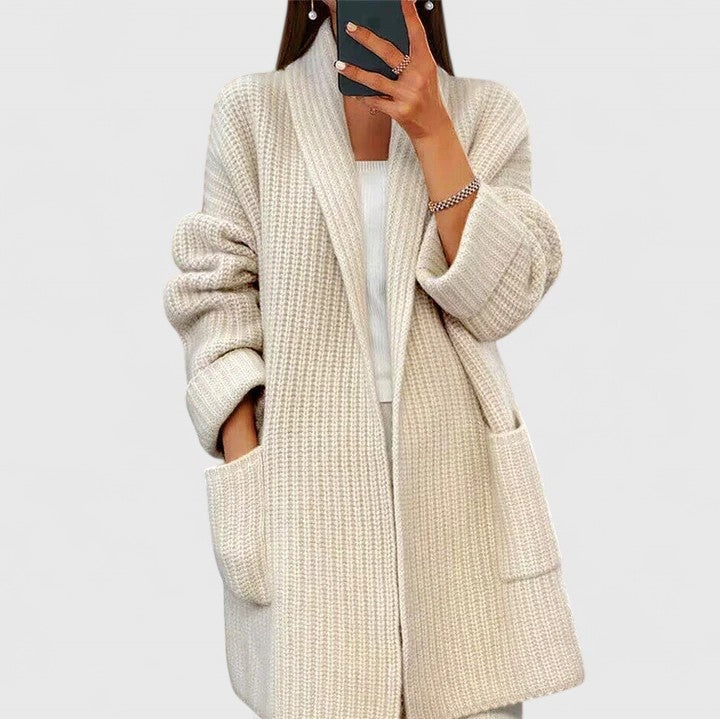 Light beige longline cardigan with an open front and two large patch pockets, shown from the front with rolled-up sleeves.