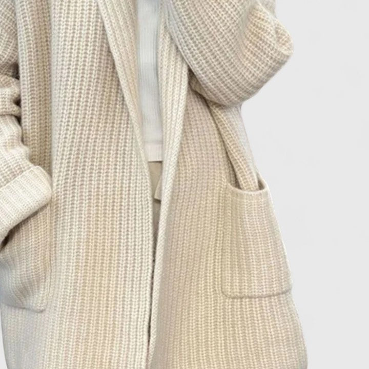 Close view of the cardigan's front, focusing on the roomy patch pocket, open front, long sleeve, and textured surface.