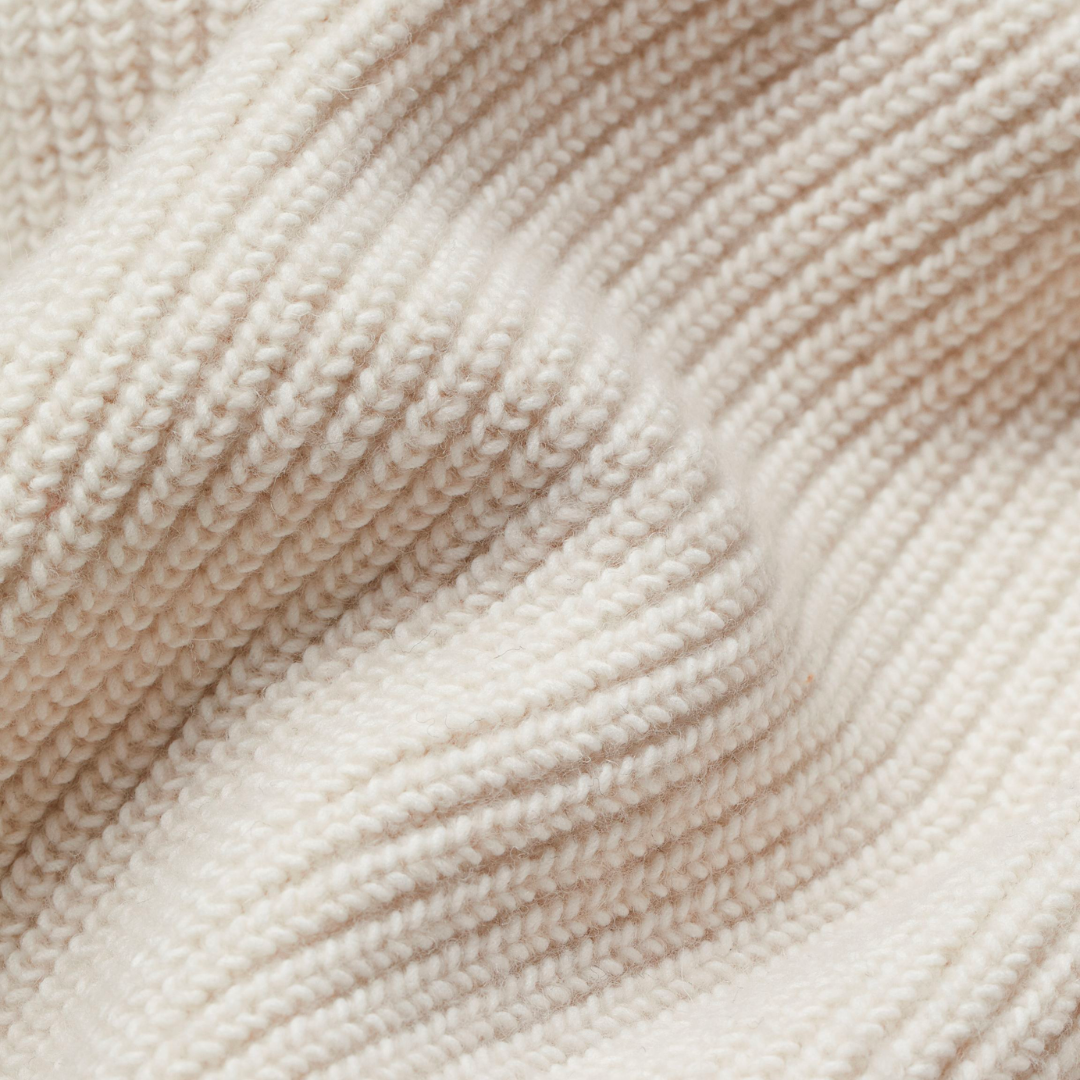 Extreme close-up of the cardigan's raised textured knit pattern and ribbed edge detail.