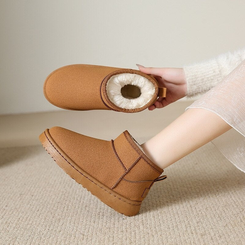 Pair of tan ankle snow boots shown from above, with the cream faux-fur lining clearly visible inside one boot.