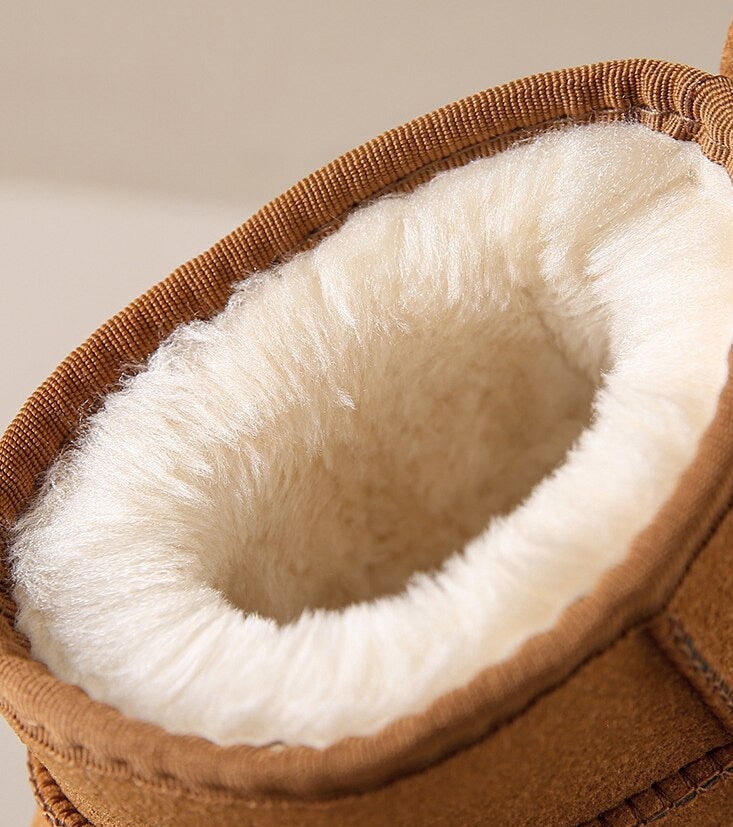 Close-up of the soft cream faux-fur lining inside a tan snow boot.
