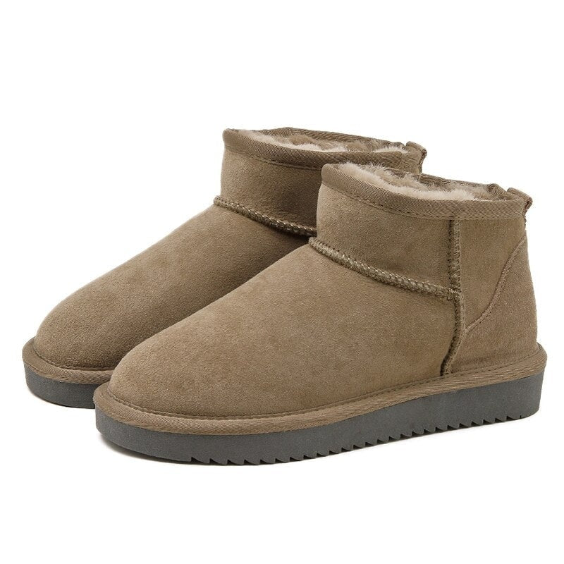 Pair of taupe low ankle snow boots with cream lining, contrasting dark textured outsoles, and pull tabs at the back.