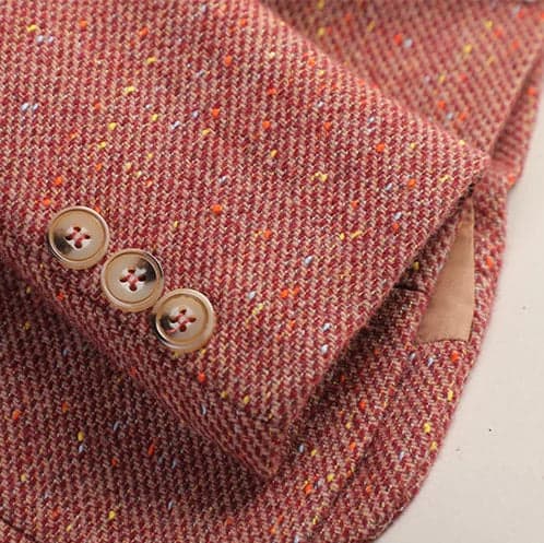 A tailored speckled blazer with notched lapels, a single button front, and front patch pockets displayed on a hanger._4