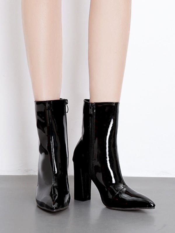 Metallic silver ankle boots with pointed toe and block heel worn with cropped jeans on a neutral surface_1