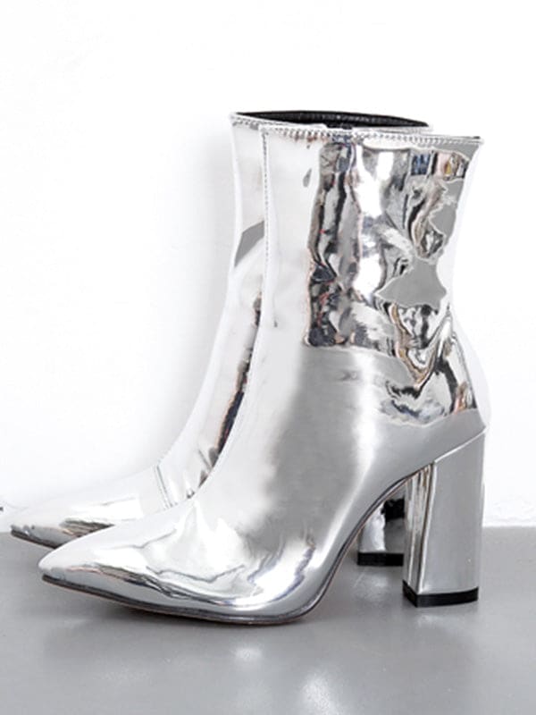 Metallic silver ankle boots with pointed toe and block heel worn with cropped jeans on a neutral surface_19