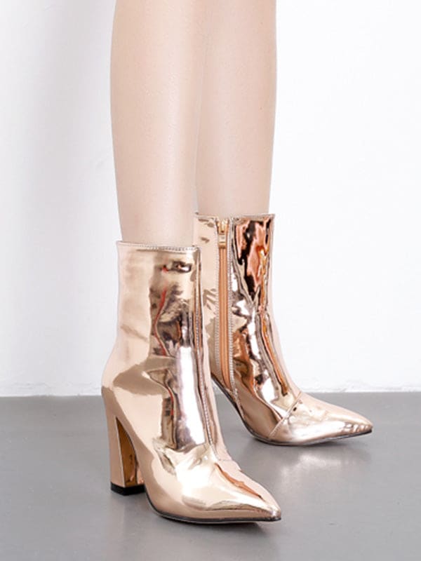 Metallic silver ankle boots with pointed toe and block heel worn with cropped jeans on a neutral surface_6