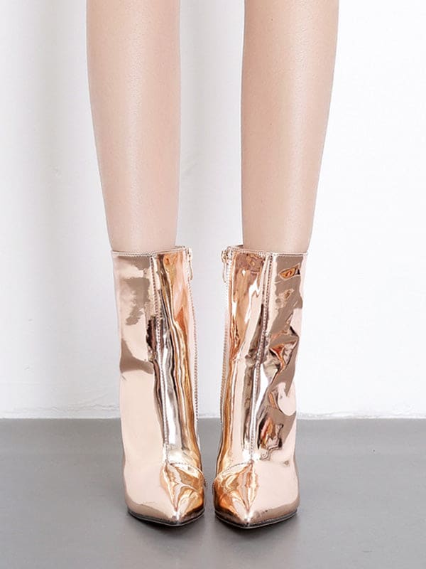 Metallic silver ankle boots with pointed toe and block heel worn with cropped jeans on a neutral surface_7