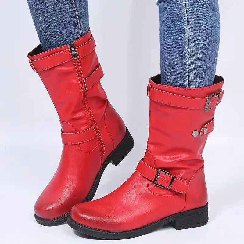 Bright red mid-calf biker boots featuring black soles, low heels, buckle straps, and side zippers.