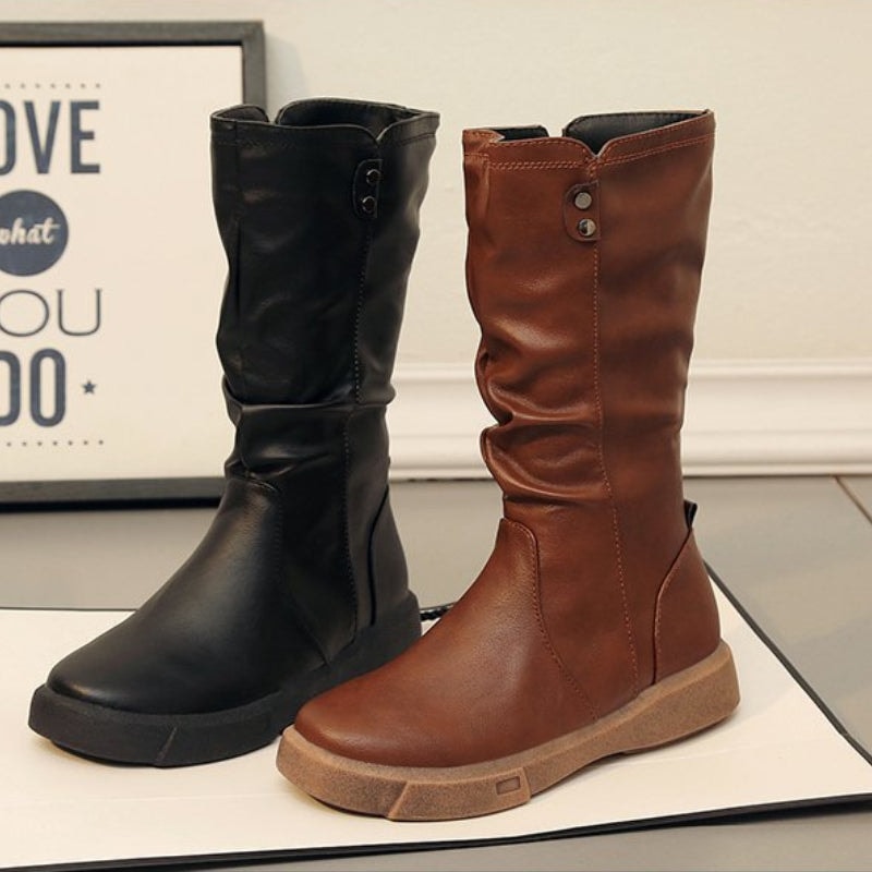 Black and brown mid-calf boots displayed side by side, showing their rounded toes, gathered shafts and low soles.
