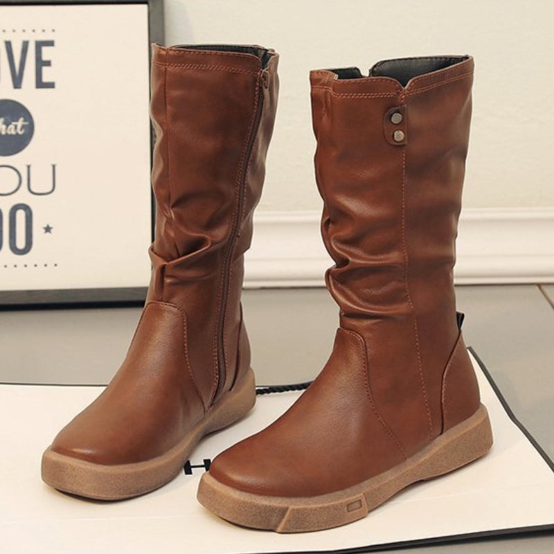 A pair of brown mid-calf boots displayed from the side and front, clearly showing the full-length side zips and softly gathered shafts.