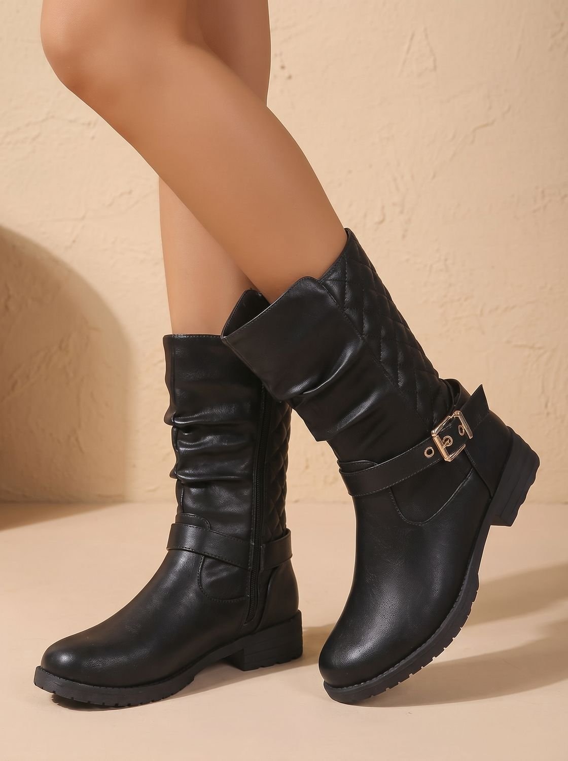 Black boots crossed at an angle, showing the slouched mid-calf shafts, ankle buckles, and sturdy low heels.