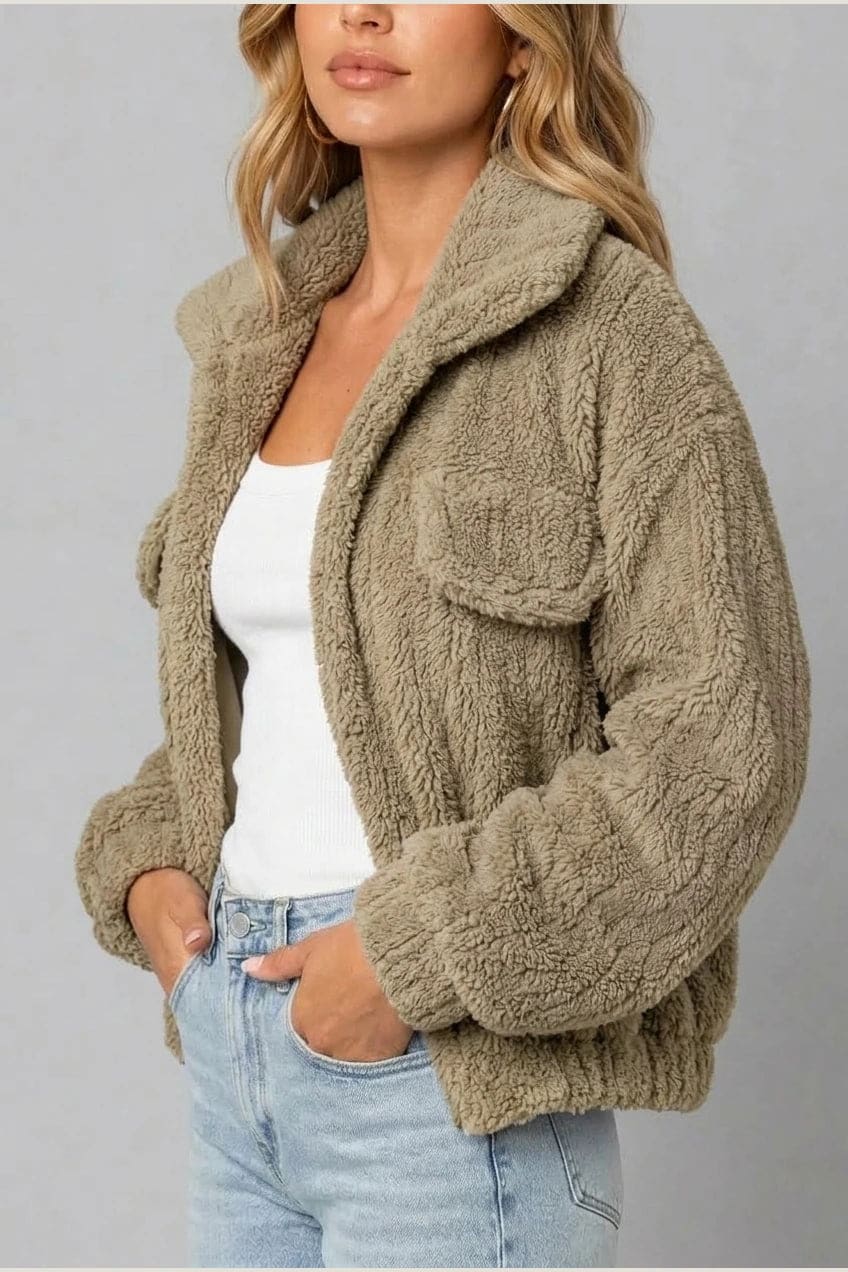 Cropped textured fleece jacket with wide collar, open front, chest flap pockets and elasticated cuffs, worn over a tank top with straight leg jeans and white trainers._16