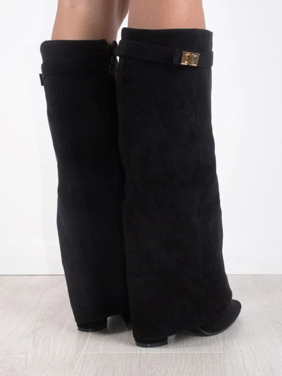 Rear view of black knee-high boots showing the back seams, fold-over cuffs, low heels, and metallic accent on one cuff.