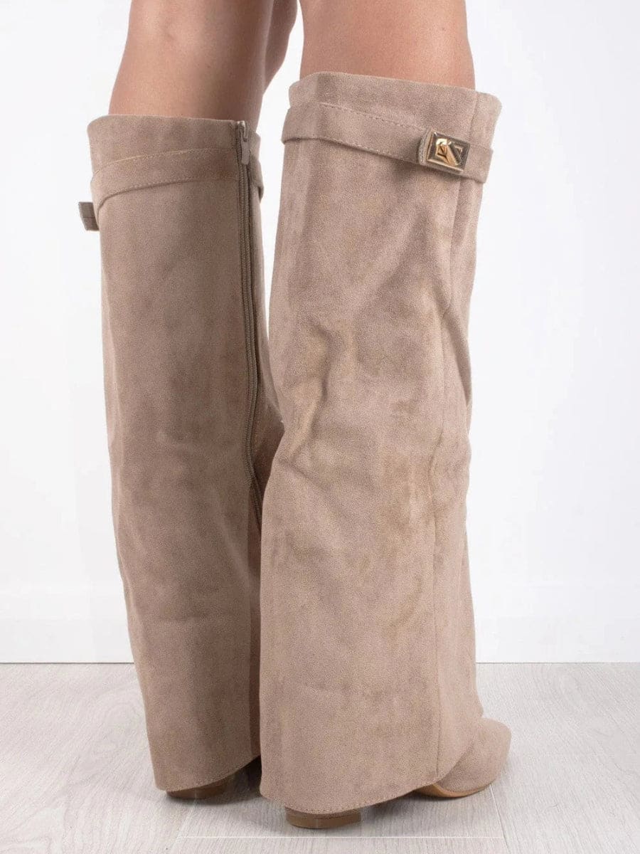 Rear three-quarter view of taupe knee-high boots showing the back zippers, fold-over cuffs, metallic accent, and low heels.