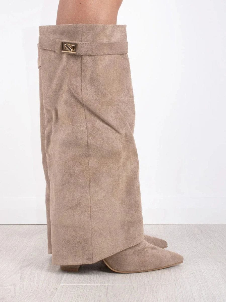 Side view of a taupe knee-high boot highlighting the pointed toe, fold-over cuff, metallic detail, and low heel.