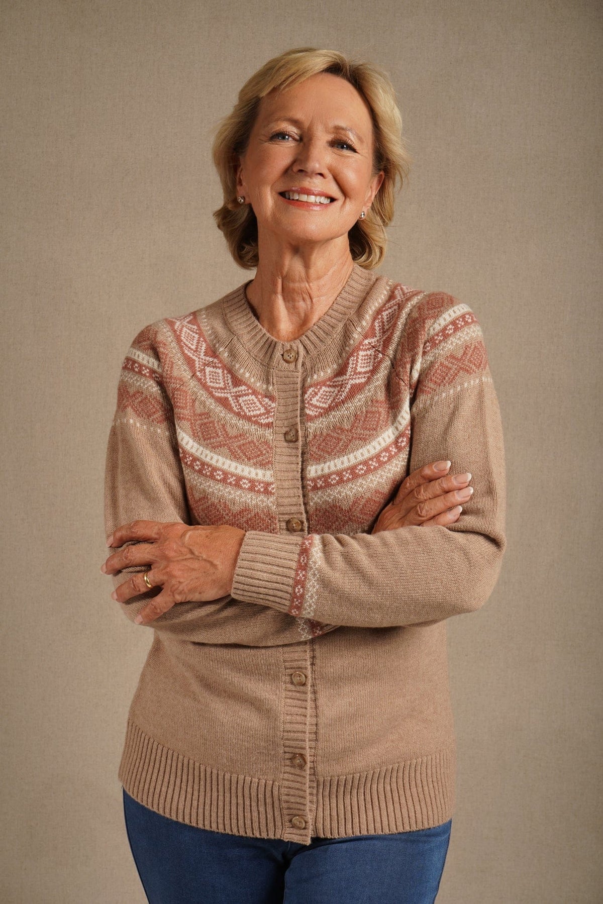 Woman standing outdoors wearing a long-sleeved button-front knit cardigan with a patterned Fair Isle yoke, ribbed crew neck, cuffs and hem, with jeans._1